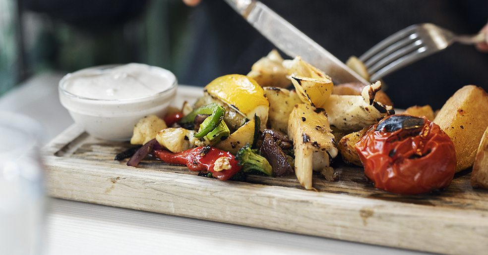 Grillade grönsaker på en planka.