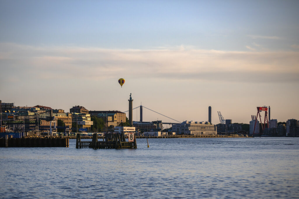 Ett foto av hamninloppet i skymning och en gul luftballong vid andra landmärken.